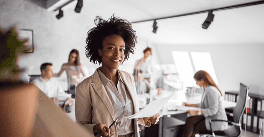 Woman smiling when holding pen and paper.